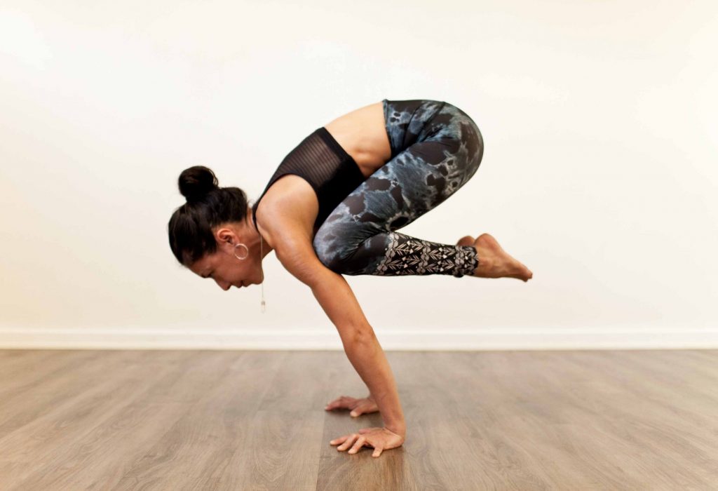 Woman doing yoga cow pose in Uppsala, Sweden using blue liforme yoga mat  on a white background